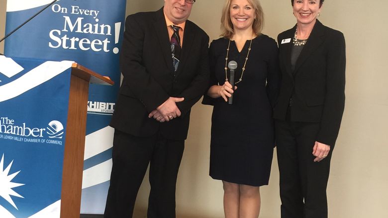 three people on stage after an event