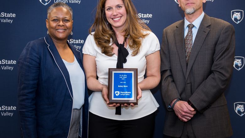 two women and man posing with an award