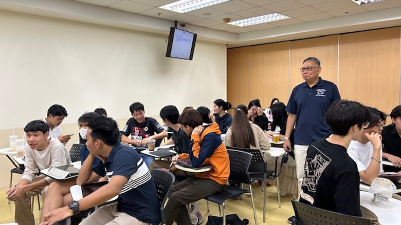 a teaching speaks to a classroom full of students