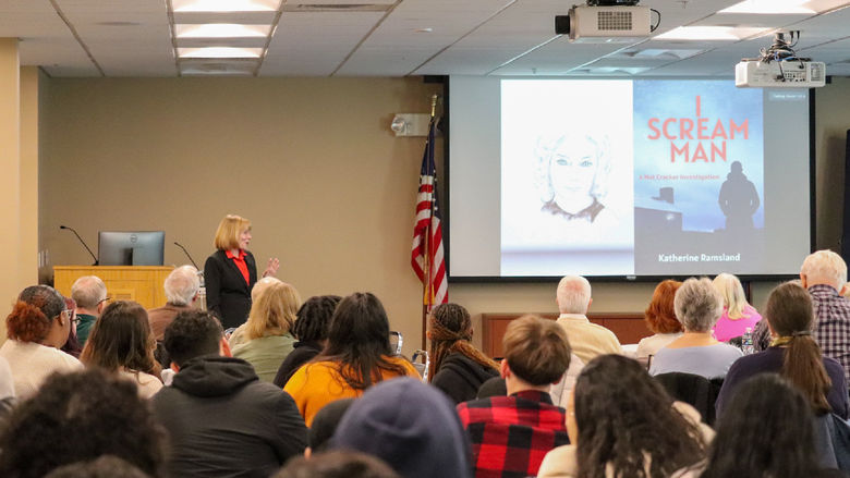 Kathrine Ramsland Speaking with Group at Penn State Lehigh Valley Pointing at Slideshow