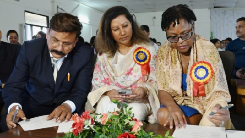 3 individuals look down at a document 