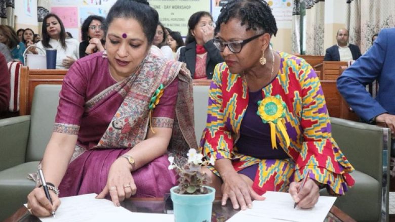 2 women look down at a document 