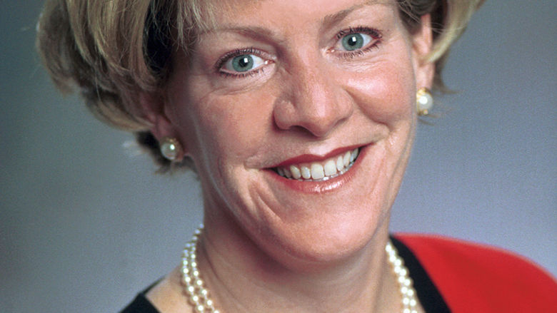 headshot of woman with short hair and in red blazer