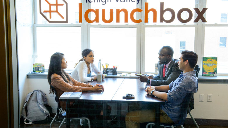 students sitting at a table interacting