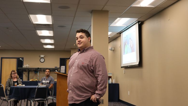 man speaking at front of the room