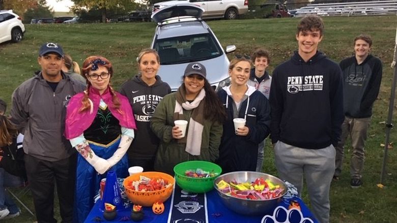 students and adults passing out candy