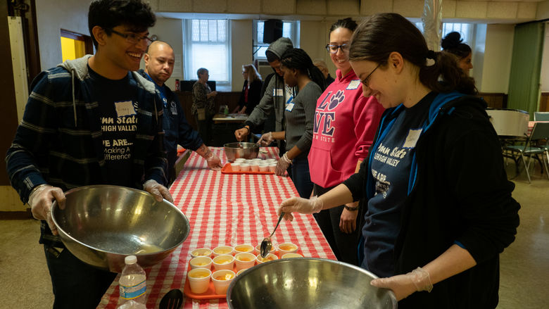 handful of people dishing food in a bowl