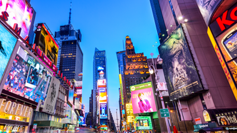 Time Square at night showing brightly lit and colorful billboards.
