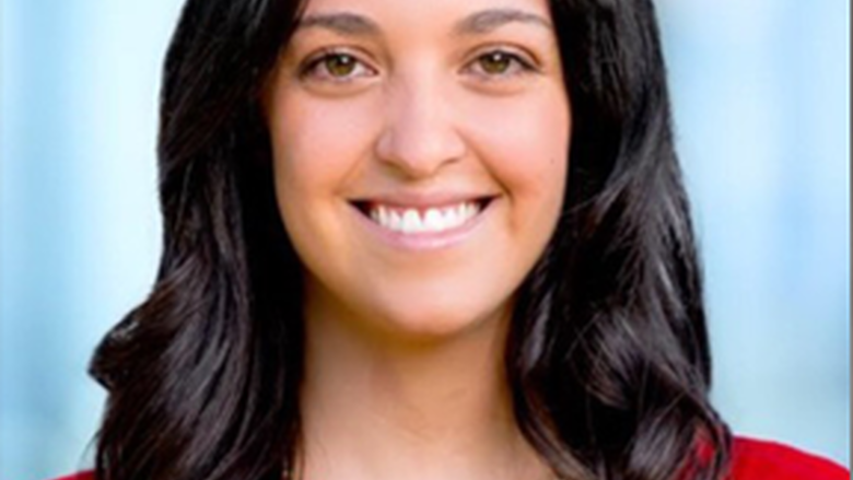 Woman smiling, looking at camera.