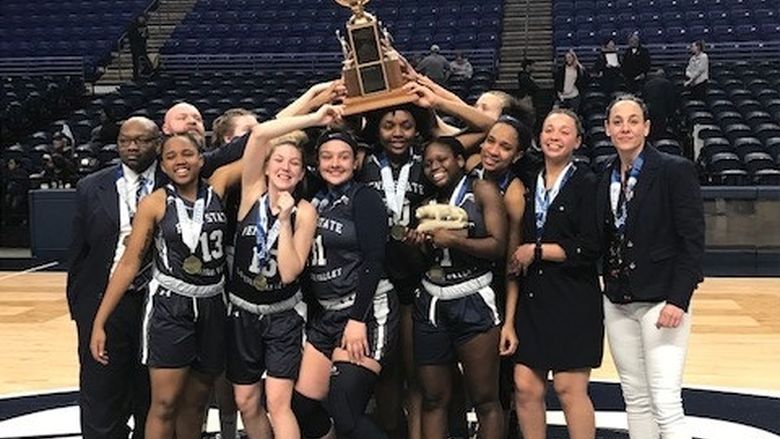 basketball team and coaches holding up trophy