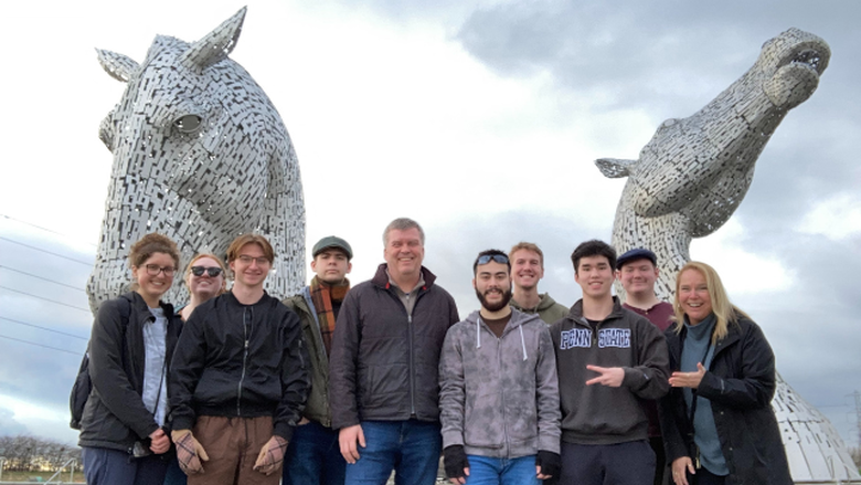 A group of eight students and two faculty advisors standing in front of  “The Kelpies”