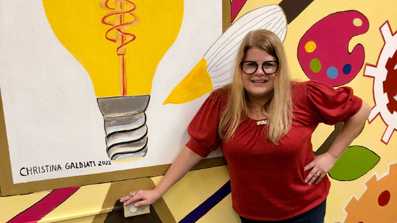 Christina Galbiati standing in front of STEAM-themed mural