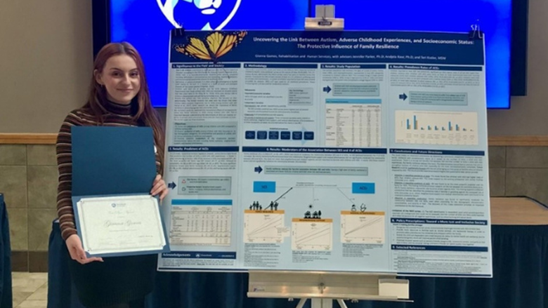 Gianna Gomes standing in front of her research poster