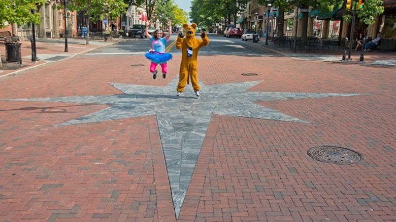 Student and Nittany Lion jump for joy in middle of Main Street in Bethlehem, Pennsylvania.