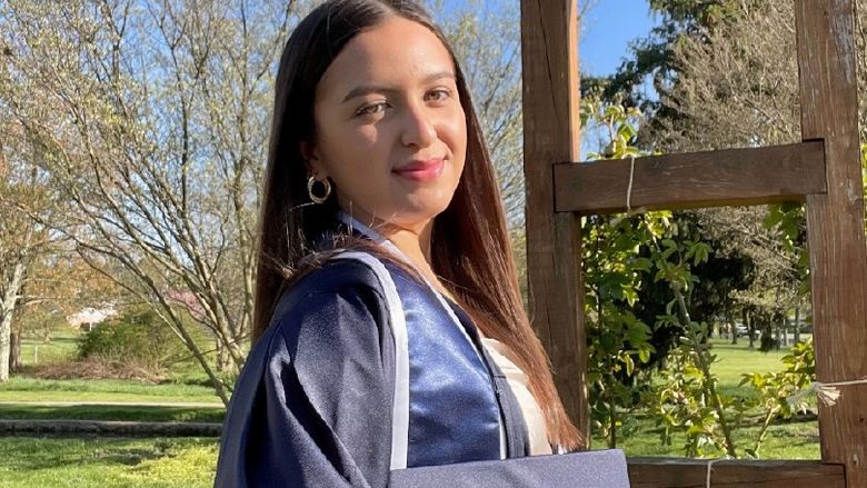 Student poses in graduation attire. 