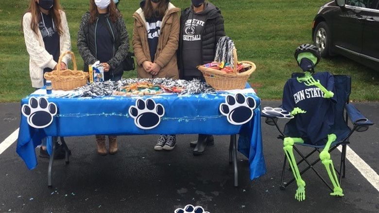 students at table handing out candy