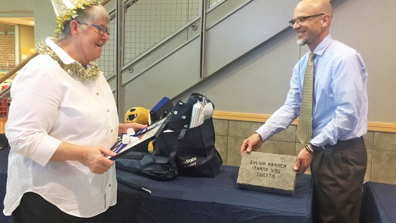 Man presents a brick to a woman