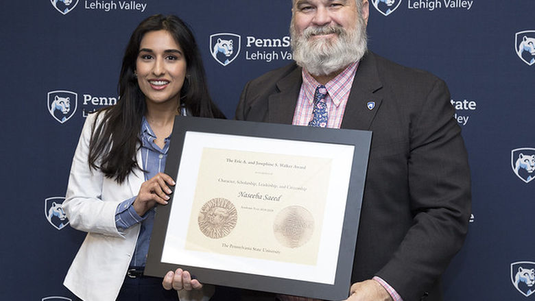 female student accepting award from man