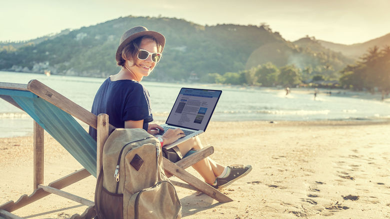 Student on beach with laptop