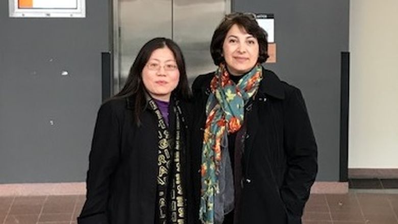 two women in front of a sign
