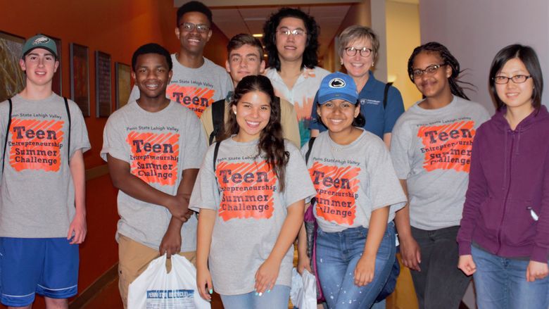 group of students smiling while visiting a building