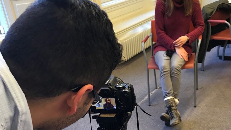 man with camera and woman being interviewed 