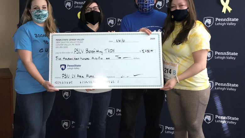Individuals holding a large check