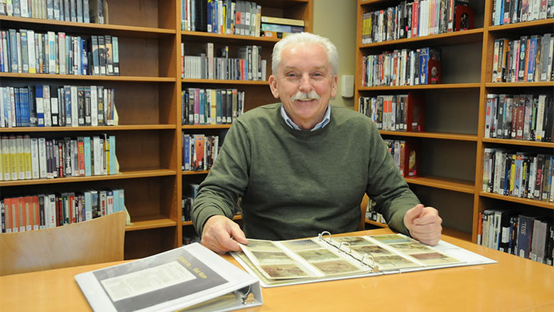 Tom Roney visiting PSU-LV library looks at his photo albums.
