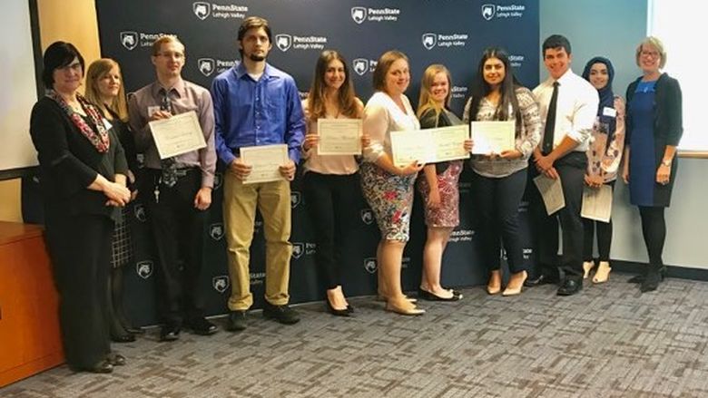 Group of students with faculty members displaying their certificates