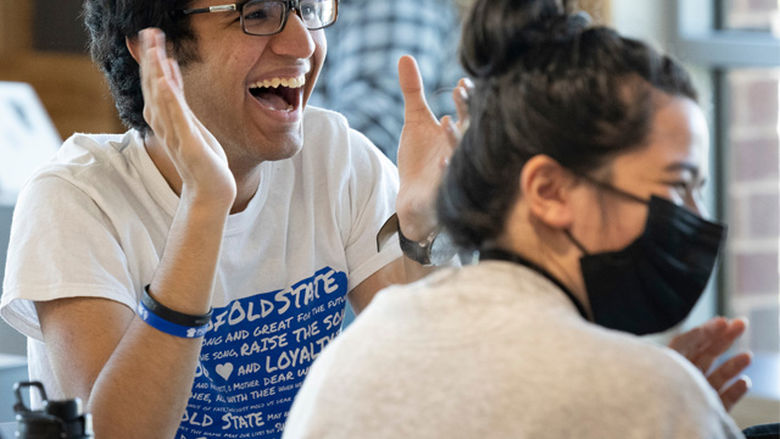 Two students laughing and clapping