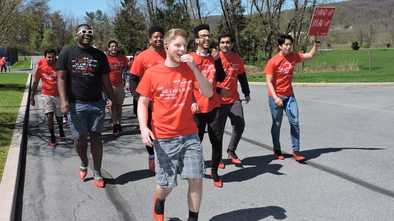 male students walking in red heels