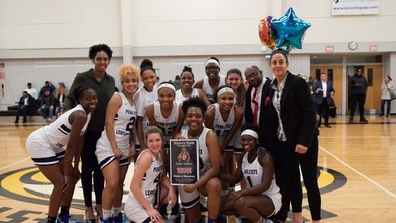 group of women basketball players posing on court with balloons