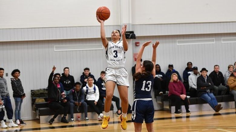 woman shooting a basketball