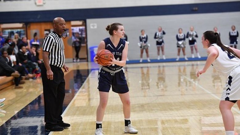 Female basketball player holding basketball in a game