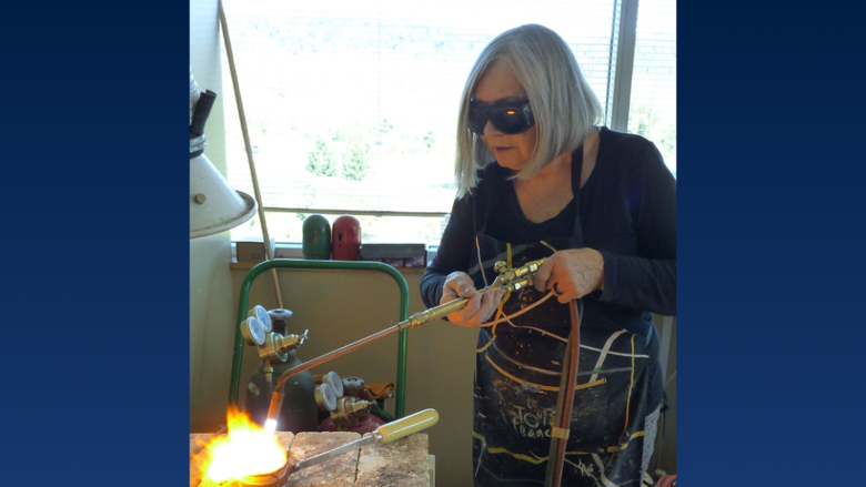 a woman wears goggles while welding