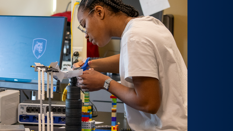 a female students works on her engineering marble run project