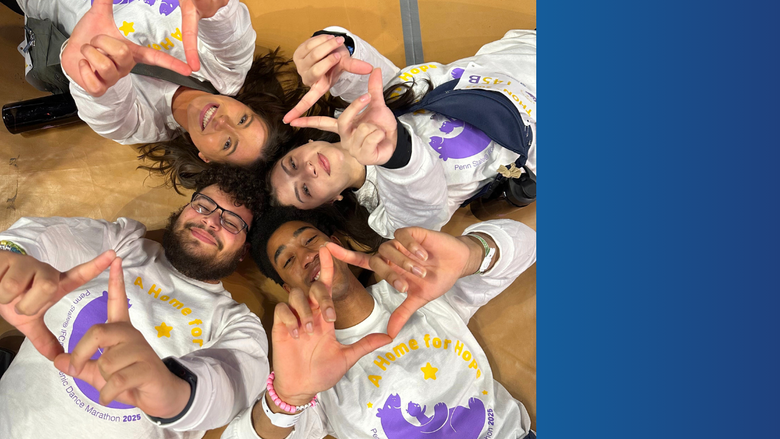 four Penn State THON dancers lay on the floor with heads touching holding up the four diamonds symbol