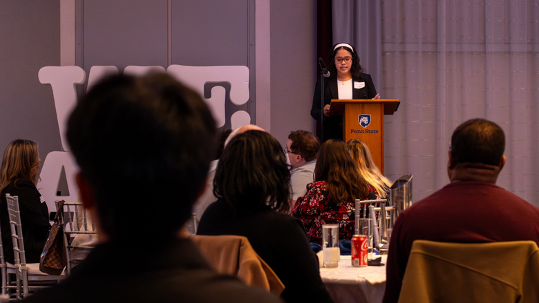 a female student speaks at a podium in a conference center 