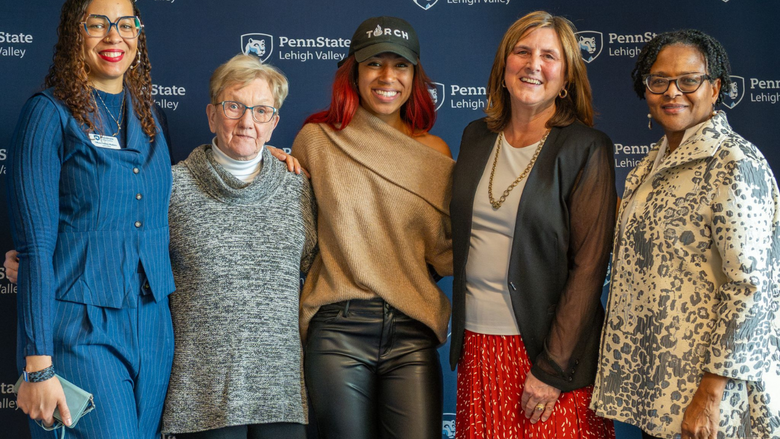 five women smile in front of a Penn State Lehigh Valley banner 
