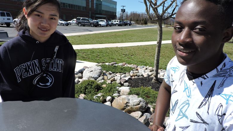 Two students sitting at a table outside of campus