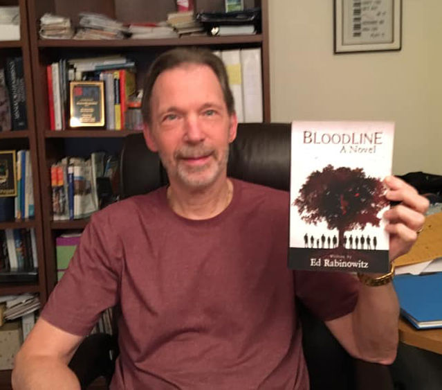 Ed Rabinowitz holds up a copy of his book, "Bloodline"