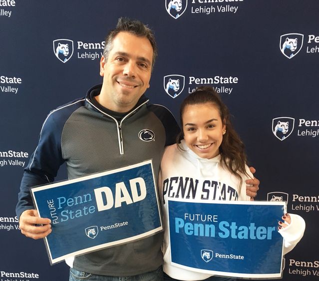 a Dad and daughter pose with Penn State Lehigh Valley signs