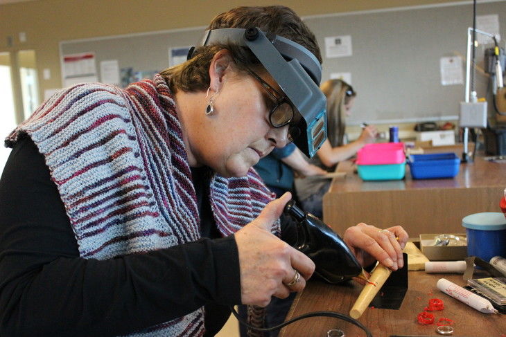 woman working on metals and jewelry