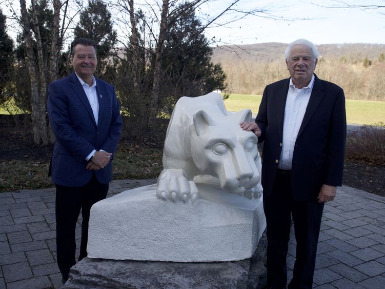 Two men flank Nittany Lion Shrine