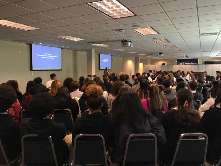 100 high school students listening to a speaker