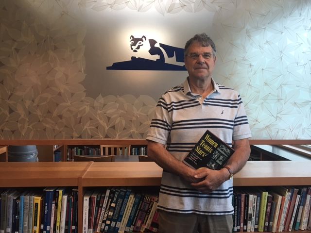 man standing in front of books 