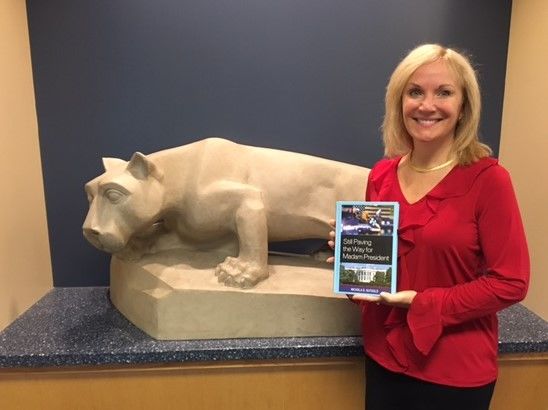 woman standing with book in front of lion statue