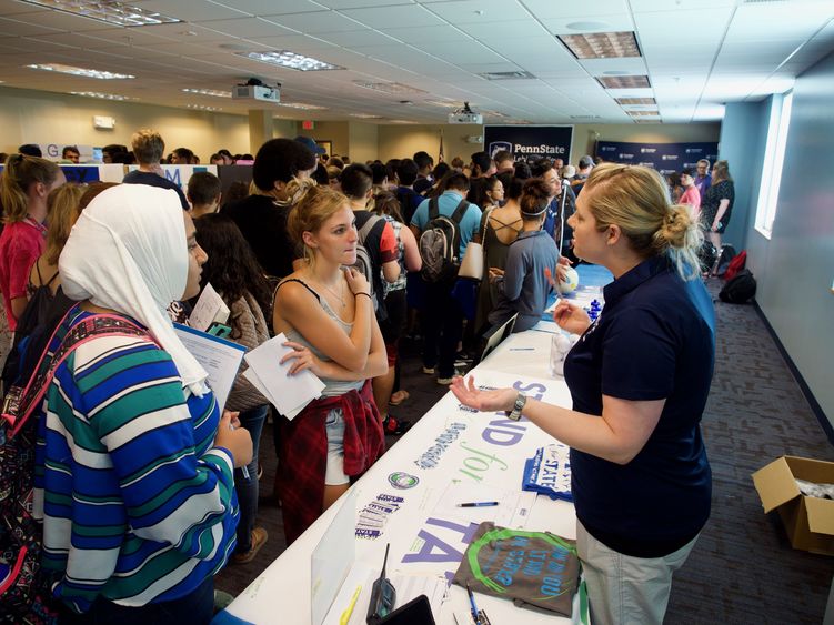 large group of students talking to club leaders at tables