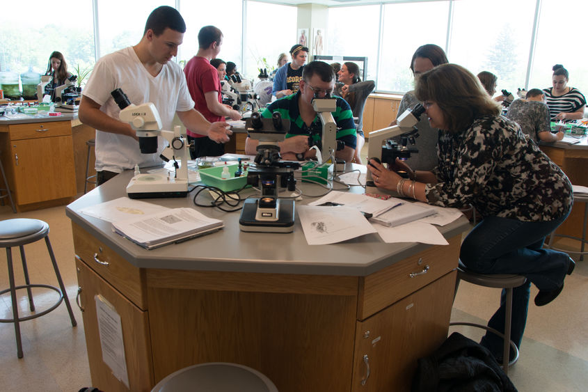 A group gathered around a lab table