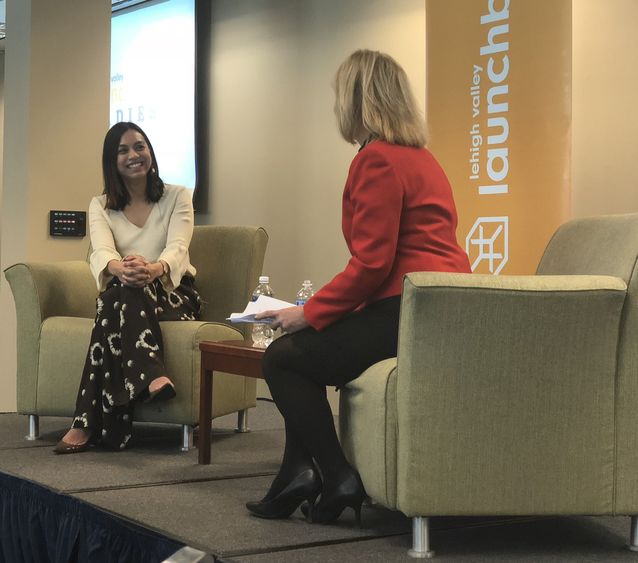 Two women on a stage interviewing